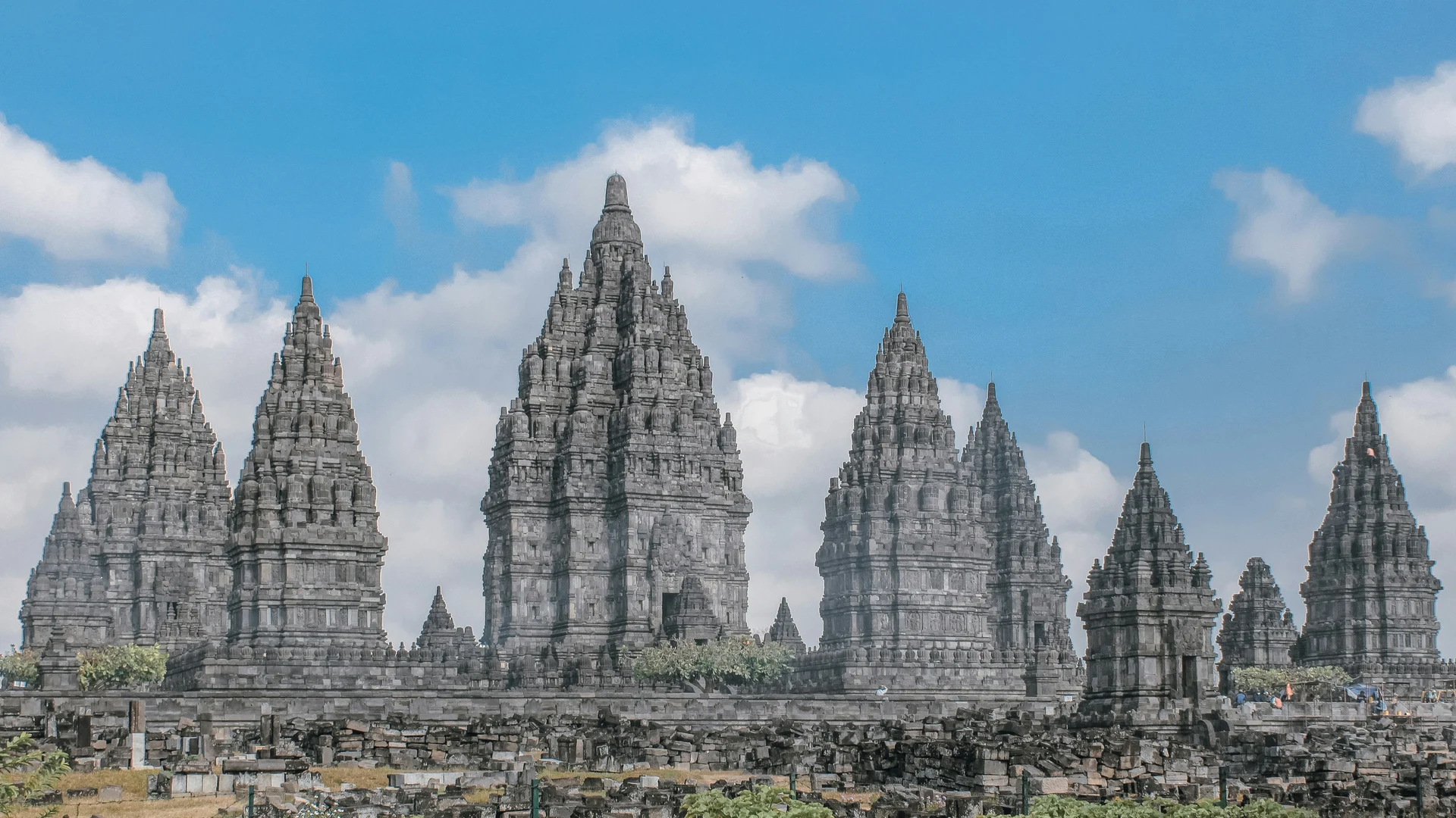 The three Trimurti towers of Prambanan rising above the temple platform at dusk